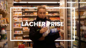 Image d’une jeune femme dans un supermarché, tenant difficilement plusieurs articles dans ses bras. Le titre “LÂCHER PRISE” est affiché en blanc et en majuscules au centre de l’image, encadré par un rectangle fin. L’arrière-plan montre des rayons remplis de produits alimentaires, créant une atmosphère familière et quotidienne. L’image illustre une scène du court-métrage, abordant la gestion du stress et de l’anxiété à travers des situations du quotidien.
